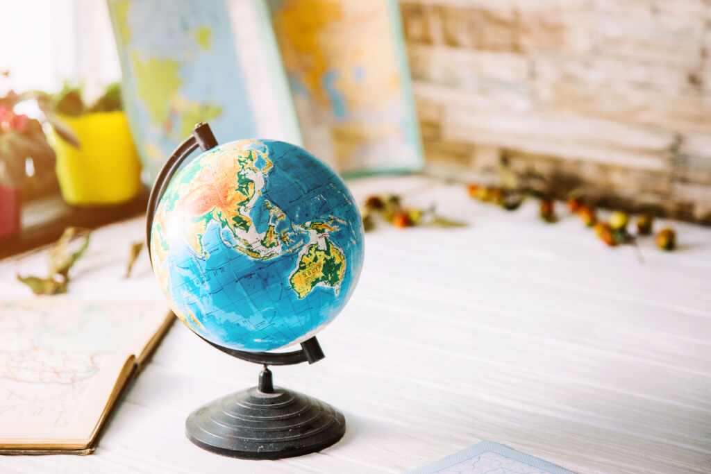 Globe,On,Wooden,White,Boards,With,A,Blurred,Background.,Autumn