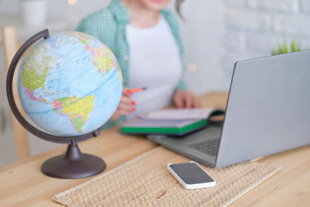 Blurred,Globe,In,The,Foreground.,In,The,Background,A,Woman